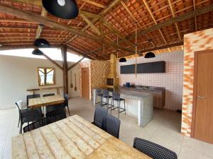 uma cozinha com mesas e cadeiras de madeira num quarto em Condomínio Villamares em Luís Correia