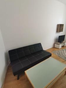 a black couch in a living room with a table at Central City Apartment in Vienna