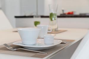 une table avec deux tasses et une assiette sur elle dans l'établissement Exklusive Ferienwohnung mit Blick auf den Yachthafen, à Peenemünde