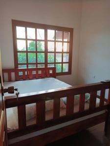 um quarto com uma cama de madeira e uma janela em Manantial de Vida em Bejuco