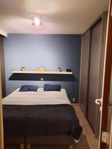 um quarto com uma cama com uma parede azul em Apollo Duinzicht em Nieuwpoort