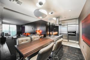 a kitchen with a wooden table and some chairs at StripViewSuites Two-Bedroom Conjoined Suite at Palms Place in Las Vegas