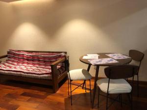a bed and a table and two stools in a room at Apartamento acogedor en Achumani in La Paz