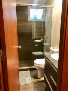 a bathroom with a toilet and a glass shower at Apartamento acogedor en Achumani in La Paz