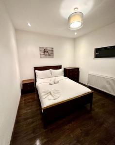 a bedroom with a bed with a bow on it at Alarabi Apartments-Peckham in London