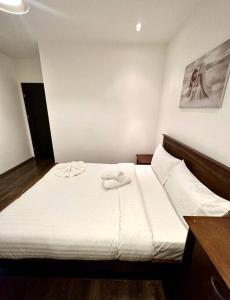 Un dormitorio con una cama blanca y una foto en la pared en Alarabi Apartments-Peckham en Londres