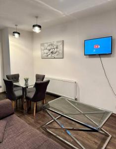 sala de estar con mesa de cristal y sillas en Alarabi Apartments-Peckham en Londres