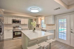a kitchen with white cabinets and a large white island at Bright, Airy Home with Pool and Grill! in Richardson