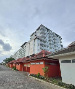 een groot appartementencomplex met een rij rode gebouwen bij Paradise Room By Vivo Apartment in Seturan