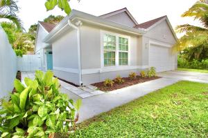 a white house with a garden in front of it at Jupiter Sunshine in Jupiter
