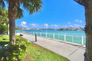 a sidewalk next to the water with a fence at Jupiter Sunshine in Jupiter