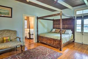 a bedroom with a four poster bed and a chair at Vintage Louisiana Vacation Rental Home in New Roads