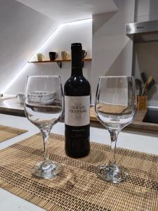 a bottle of wine and two wine glasses on a table at Acogedor apartamento loft in Alhaurín de la Torre