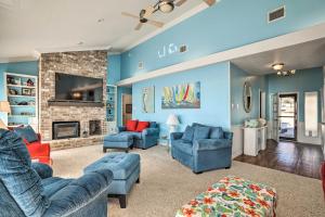 a living room with two blue couches and a fireplace at Lakefront Livingston Home with Grill and Views! in Blanchard