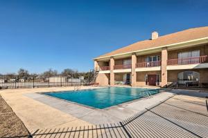 a swimming pool in front of a building at Lakefront Livingston Home with Grill and Views! in Blanchard