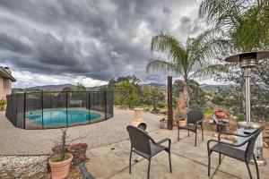 un patio trasero con piscina, sillas y una palmera en Awesome Poway Home with Private Pool!, en Poway