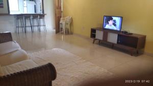 a living room with a tv and a couch at Chale do vale in Porto Seguro