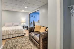 a bedroom with a bed and a leather couch at Atlanta Area Studio ~ 3 Mi to Gas South Arena! in Lawrenceville