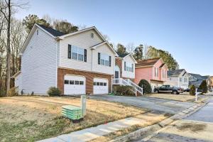 a house with a white garage in a residential neighborhood at Atlanta Area Studio with Creek Access! in Lawrenceville