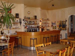 a bar in a restaurant with tables and chairs at Les Epis d'Or in LʼIsle-sur-Serein