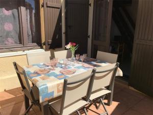 une table avec des verres et un vase de fleurs sur elle dans l'établissement Appartement Port Leucate, 3 pièces, 6 personnes - FR-1-81-47, à Port-Leucate