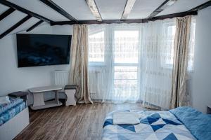 a bedroom with a bed and a large window at LaBebe - Vidraru in Arefu