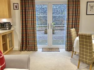 a living room with a sliding glass door at Brodie Cottage in Killin