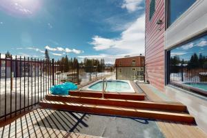 a hot tub on a deck next to a fence at The Sanctuary Bldg 5 #7-8 in Winter Park