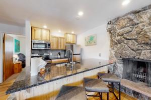 a kitchen with a fireplace and a stone wall at The Sanctuary Bldg 5 #7-8 in Winter Park