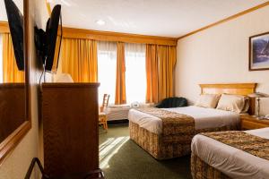 a hotel room with two beds and a window at Hotel Sicomoro in Chihuahua