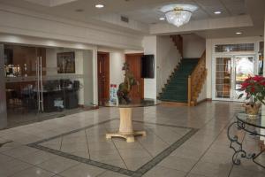 a lobby with a table in the middle of a room at Hotel Sicomoro in Chihuahua