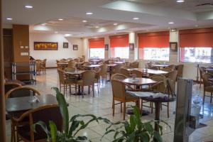 a dining room filled with tables and chairs at Hotel Sicomoro in Chihuahua