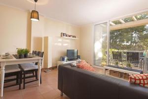 sala de estar con sofá, mesa y ventana en Preciosa zona natural La Mora en Tarragona