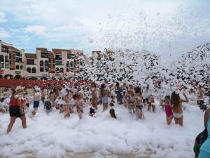 eine Menschenmenge, die am Strand in Schaum spielt in der Unterkunft Studio Port Barcarès, 2 pièces, 4 personnes - FR-1-195-25 in Le Barcarès