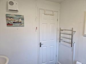 ein Bad mit einer weißen Tür und einer Leiter für Handtücher in der Unterkunft Caldon Holiday Chalet sleeps 4 in Dartmouth WIFI Electric inc Pet friendly in Dartmouth + 39 Fotos
