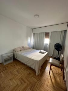 een slaapkamer met een bed, een stoel en een tafel bij Departamento de Lis in Mendoza