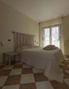 a white bedroom with a bed and a window at Appartamento Mimosa in Ripa Teatina