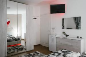 Habitación blanca con lavabo y espejo en TROPICAL ROOM Vista Mare, en Cirò Marina
