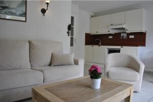 een woonkamer met een bank en een tafel bij L'ES-CALE DE BEG-MEIL AVEC PISCINE ET PLAGE Appartement avec 1 chambre et 1 alcôve in Fouesnant