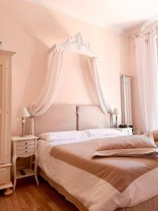biała sypialnia z dużym łóżkiem z baldachimem w obiekcie Trastevere Belvedere B&B w Rzymie