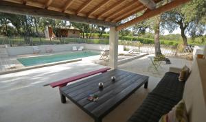patio con tavolo e piscina di Les Cabanes de Carelle ad Aspères