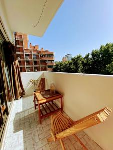 a balcony with two benches and a table on it at Pampa Downtown Lodge in Mendoza