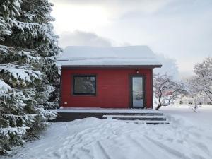 a red cabin in the snow with snow covered trees at Kuusekoda in Käina