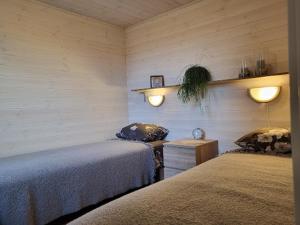 1 dormitorio con 2 camas y luces en la pared en Kuusekoda en Käina