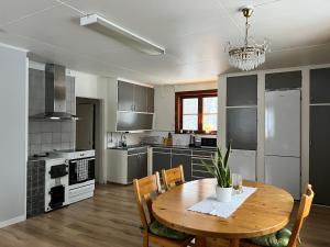 une cuisine avec une table en bois et une salle à manger dans l'établissement Trevlig villa mellan sjöarna i Vistträsk By., à Vistheden