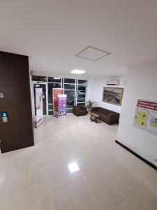 een grote kamer met banken en tafels in een gebouw bij Paradise Room By Vivo Apartment in Seturan