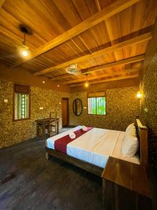 a bedroom with a large bed with a wooden ceiling at Walawa Dreams Safari Resort in Udawalawe