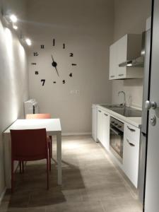 una cucina con tavolo e orologio sul muro di Paoli 28 Holiday Homes a Corato