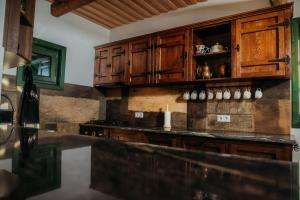 cocina con armarios de madera y encimera en Huta Village, en Piatra