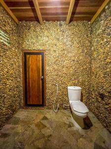 y baño con aseo en una pared de piedra. en Walawa Dreams Safari Resort en Udawalawe